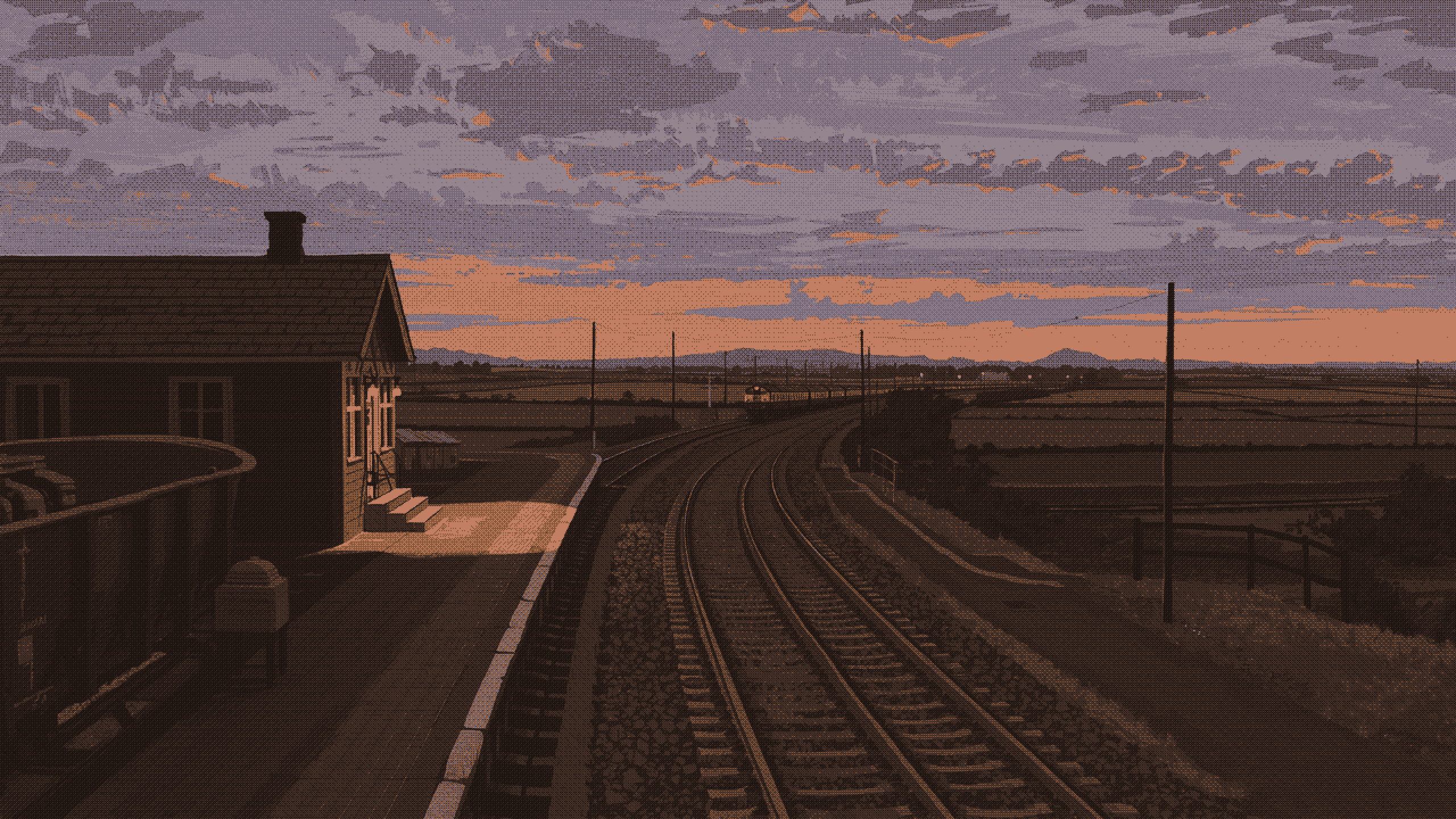 A country railway station at dusk, the rails curving away into the fields